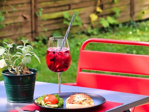 a table with a plate of food and a glass of wine at ibis Hotel Regensburg City in Regensburg