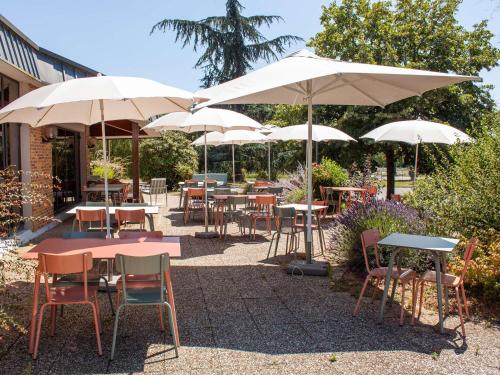 a group of tables and chairs with umbrellas at ibis Amboise in Amboise