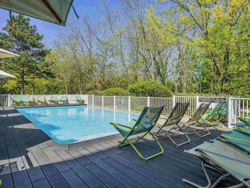 a group of chairs sitting next to a swimming pool at Novotel Toulouse Centre Compans Caffarelli in Toulouse