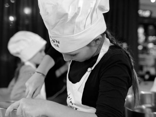 a woman in a chefs hat is preparing food at Novotel Toulouse Centre Compans Caffarelli in Toulouse