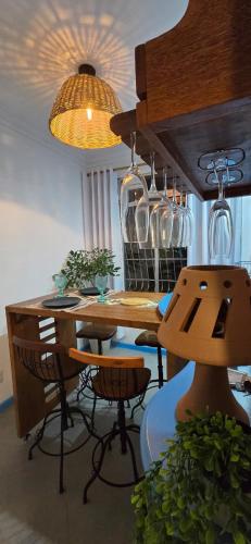 a dining room with a wooden table with chairs and glasses at Ap107 Espaço Aconchegante com Toque Mediterrâneo in Vitória