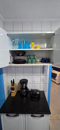 a kitchen with a black counter top in a room at Ap107 Espaço Aconchegante com Toque Mediterrâneo in Vitória
