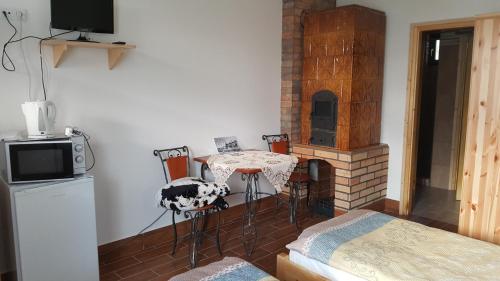 a living room with a table and a fireplace at Gesztenyés Vendégház in Garáb