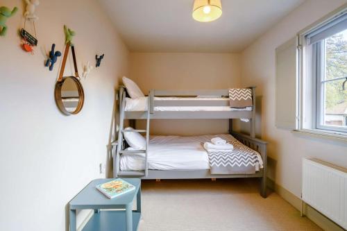 a room with two bunk beds and a window at Yew Tree House in Weybourne