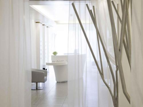 a room with a chair and a desk and a window at Novotel Marseille Vieux Port in Marseille