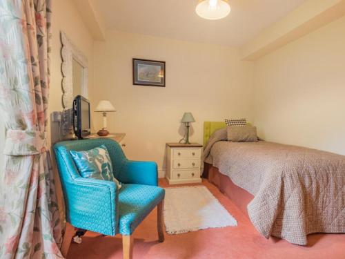 a bedroom with a bed and a blue chair at 4 Bed in Patterdale SZ170 in Patterdale