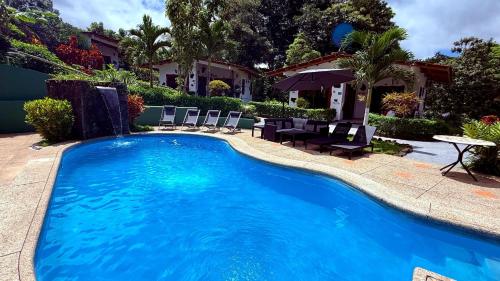 a swimming pool with chairs and a table next to a house at Piedras Blancas Lodge in Puerto Ayora