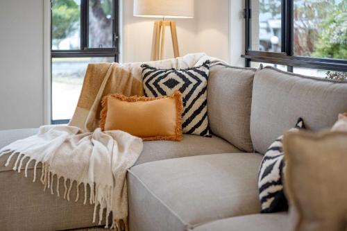 a living room with a couch with pillows on it at Beach Holiday Villa Jervis Bay in Vincentia