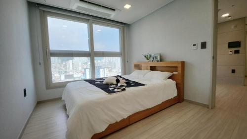 釜山にあるCentral Height Apartment Superiorのぬいぐるみが置かれたベッドのある寝室