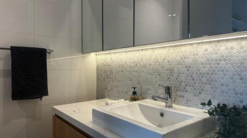 ボックスヒルにあるWhitehorse SkyHomeの洗面台と鏡のある白いバスルーム