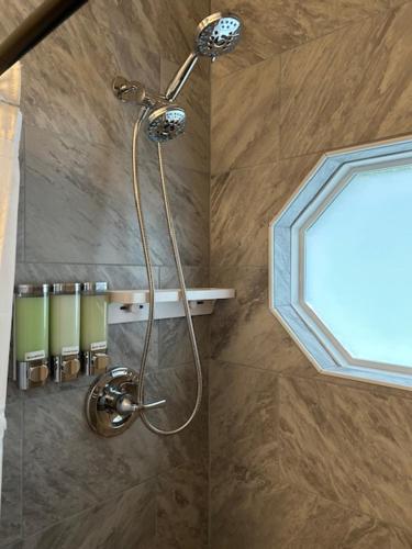 a shower with a shower head in a bathroom at Hibiscus Retreat fully equipped guest studio in Fayetteville