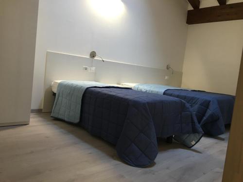 two beds in a room with blue blankets at Dune Prestige & Chalets in Bibione