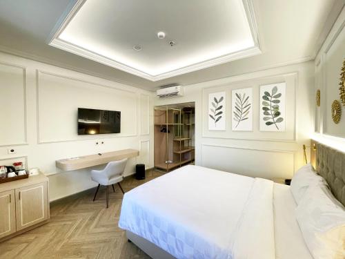 a bedroom with a bed and a desk and a tv at Hotel Bisanta Bidakara Tunjungan in Surabaya