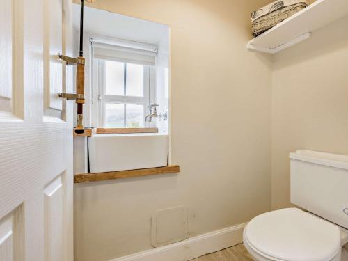 a bathroom with a toilet and a window at 3 Bed in Kirriemuir 37440 in Kirriemuir