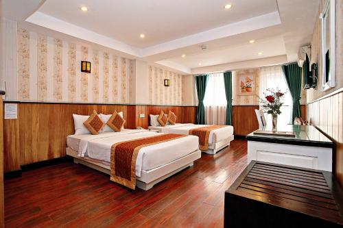 a hotel room with two beds and a window at Golden Rain 2 Hotel Nha Trang Beach in Nha Trang