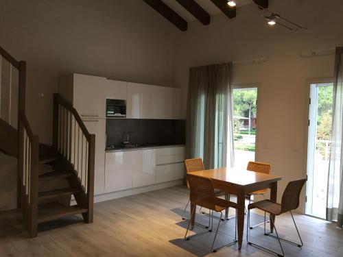 a kitchen and dining room with a table and chairs at Dune Prestige & Chalets in Bibione
