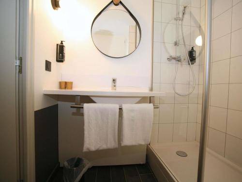 a bathroom with a sink and a mirror at ibis Saint-Lô in Saint Lo