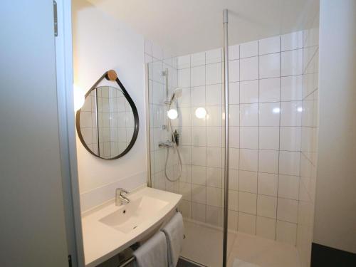 a bathroom with a shower and a sink and a mirror at ibis Saint-Lô in Saint Lo