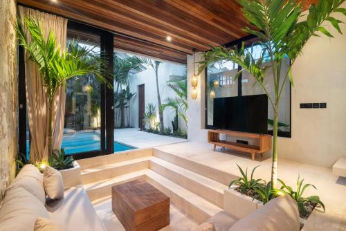 a living room with a couch and a tv at Blacksand Villas Bingin, Uluwatu by Sandara in Uluwatu