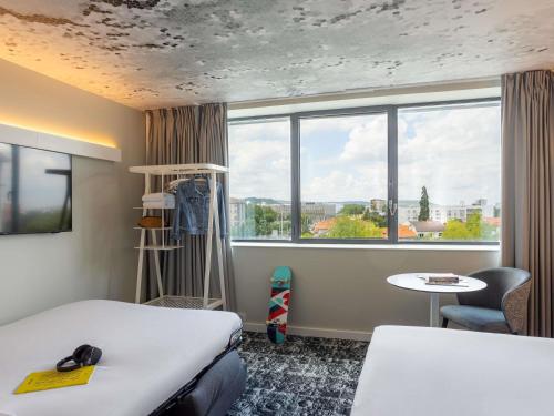 a room with a bed and a window at ibis Clermont Ferrand Montferrand in Clermont-Ferrand