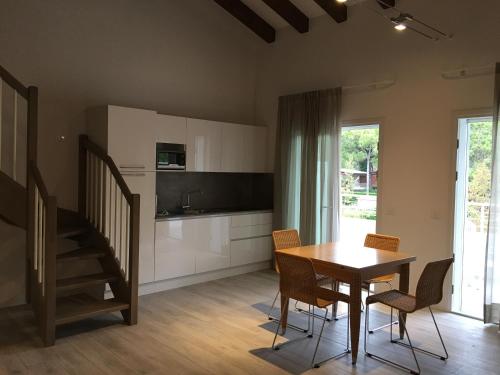 a kitchen and dining room with a table and chairs at Dune Prestige & Chalets in Bibione