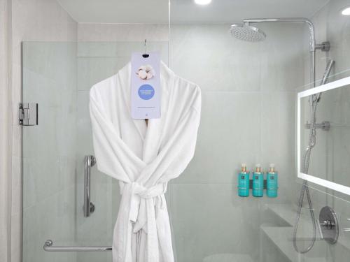 a bathroom with a shower with a white bath towel at The Novotel Toronto Centre in Toronto