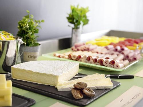 a table topped with a slab of cheese and other foods at The Novotel Toronto Centre in Toronto