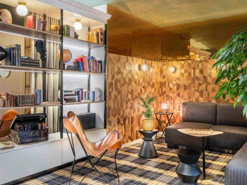 a living room with a couch and a table and chairs at Mercure Paris Bercy Bibliothèque in Paris