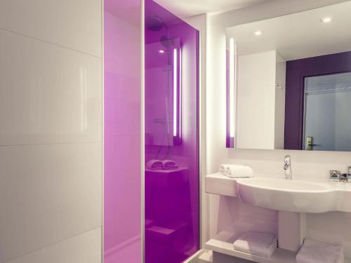 a white bathroom with a sink and a mirror at Mercure Paris Bercy Bibliothèque in Paris