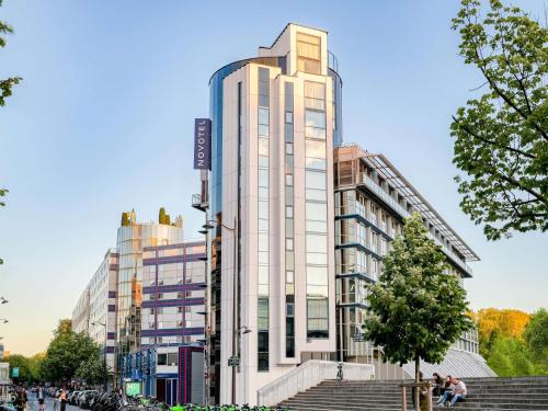 a tall white building with stairs in front of it at Novotel Paris Centre Bercy in Paris