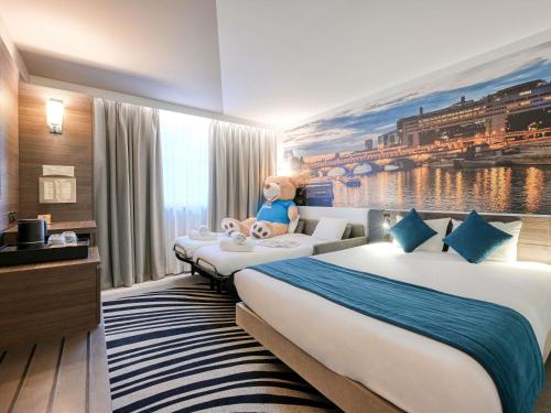 a hotel room with two beds and a mural at Novotel Paris Centre Bercy in Paris