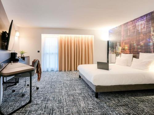 a hotel room with a bed and a desk at Novotel Paris Centre Bercy in Paris