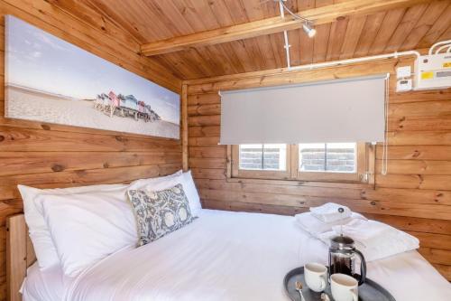 a bedroom with a bed in a wooden cabin at Old Cottage The Log Cabin in Bacton
