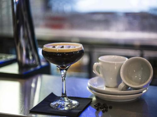 a glass of wine next to a cup of coffee at Novotel York Centre in York