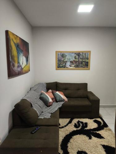 sala de estar con sofá y pinturas en la pared en Apto perto Shopping, Castelli, Unitri, AABB, Palácio de Cristal, en Uberlândia