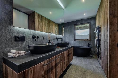 a bathroom with two sinks and two mirrors at Chalet Pfarriweg Modern luxury in Sankt Anton am Arlberg
