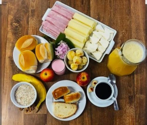 a table with a breakfast of cheese and fruit and a cup of coffee at Casa formosa in Porto Seguro