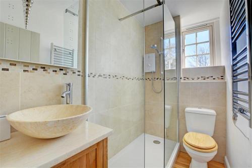 a bathroom with a sink and a toilet and a shower at Lavender Cottage in North Creake