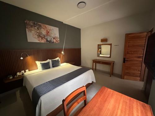 a bedroom with a bed and a table and a mirror at Hotel Pastora in Córdoba