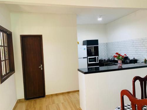 a kitchen with white walls and a counter with a stove top oven at Jesaluguel-de-casa in Cabo Frio