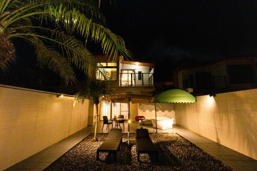a patio at night with a table and chairs at Alpha Terrace Motobu Hills in Motobu