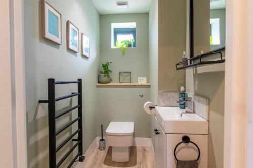 a small bathroom with a toilet and a sink at No.3 Long Barn in Wangford