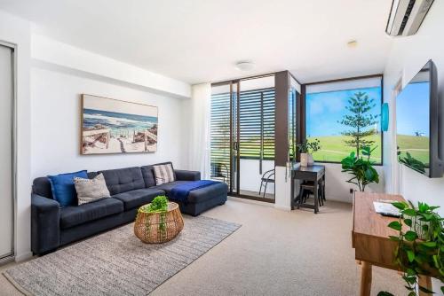 a living room with a blue couch and a table at 212 - Amazing Apartment - Near Beach in Newcastle