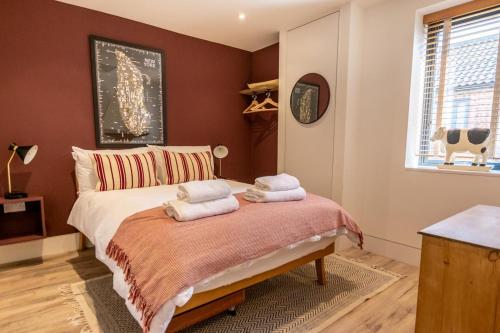 a bedroom with a bed with towels on it at No.3 Long Barn in Wangford