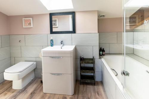 a bathroom with a sink and a toilet and a shower at No.3 Long Barn in Wangford