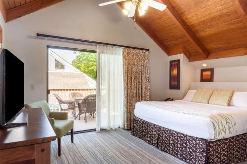 a bedroom with a bed and a tv and a balcony at Hilton Vacation Club MountainLoft Gatlinburg in Gatlinburg