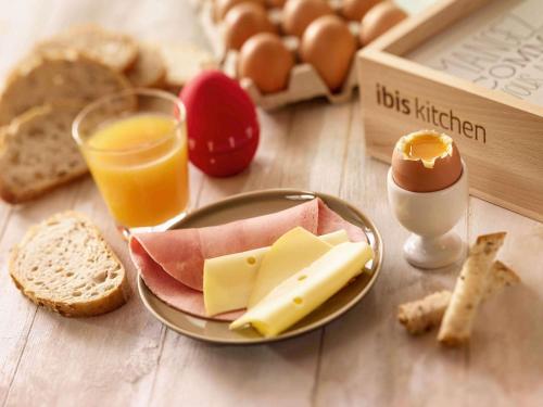 a table with a plate of cheese and eggs and bread at ibis Le Puy-en-Velay Centre in Le Puy en Velay