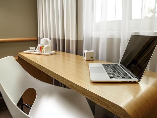 a laptop computer sitting on a wooden desk at ibis London Greenwich in London