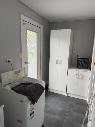 a bathroom with a sink and white cabinets at Boyanup West Wing in Boyanup