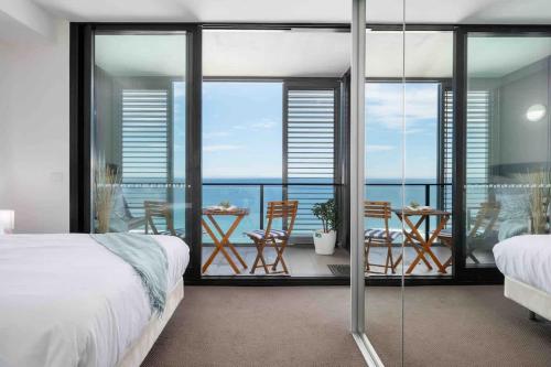 a bedroom with a balcony with a view of the ocean at 806 - Beachfront Beauty - Prices Slashed Until Dec 2025 in Newcastle